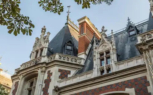 Neorenesansowa fasada Hôtel Gaillard w Cité de l'Économie Ozdobna neorenesansowa fasada muzeum Cité de l'Économie w Paryżu z czerwonej cegły i wieżyczkami.