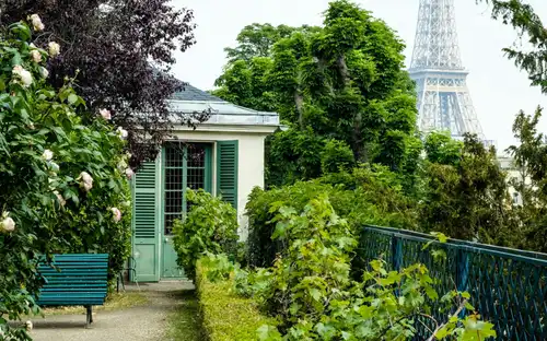 Tuinpad en bankje richting Maison de Balzac met de Eiffeltoren in de verte.