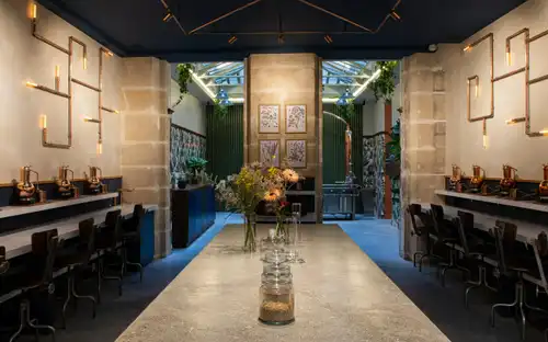 Het interieur van Distillerie de l'Arbre Sec met traditionele koperen distilleerketels en botanische displays.