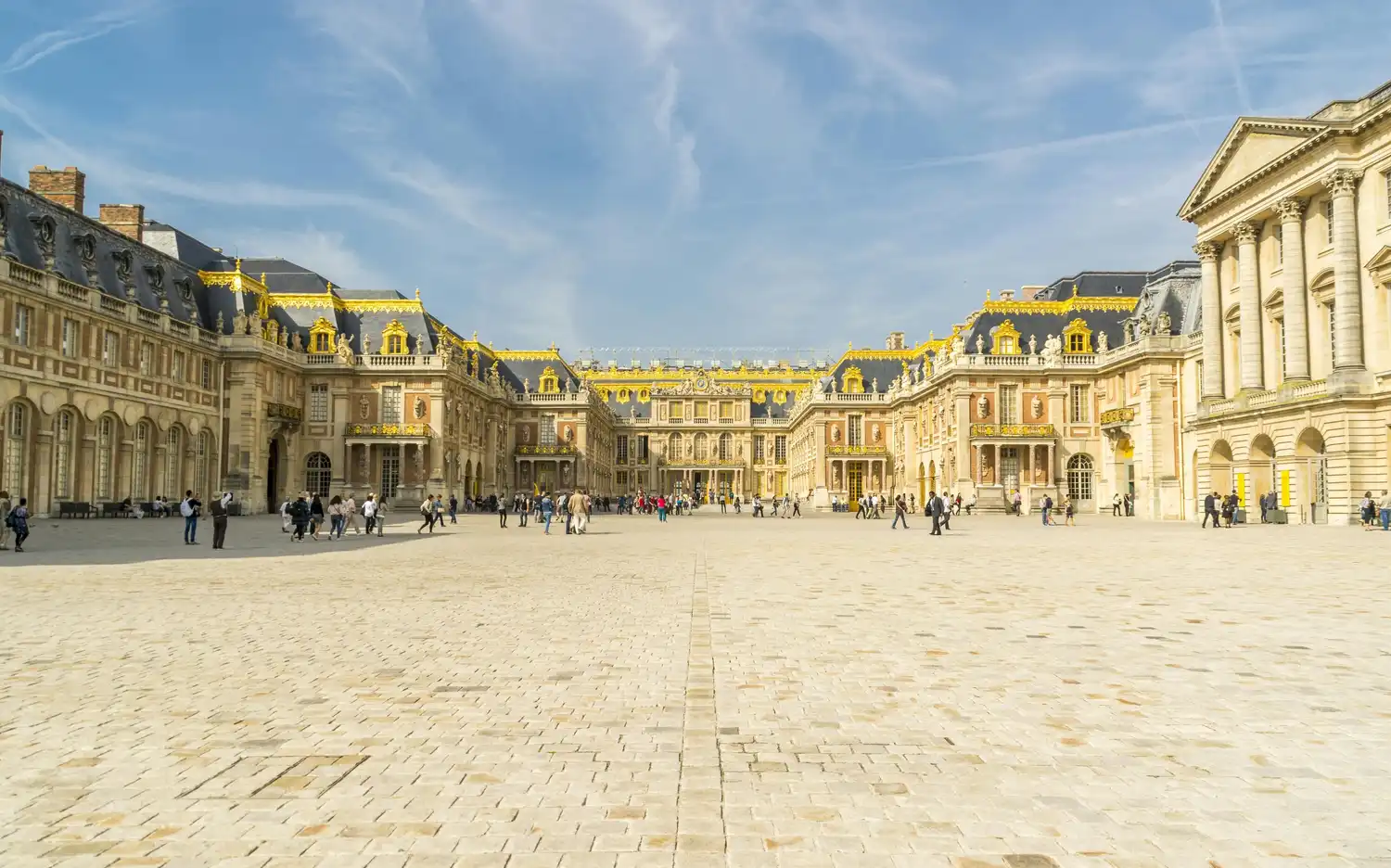 Cour d'un grand palais avec des décorations dorées sur les toits. Des gens se promènent et prennent des photos par une journée ensoleillée. Cour d'un grand palais avec des décorations dorées sur les toits. Des gens se promènent et prennent des photos par une journée ensoleillée.