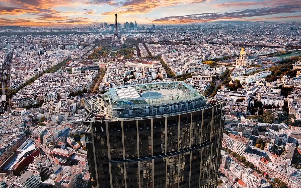 Возвышенный вид на городской пейзаж с выдающимся небоскребом на переднем плане, с зоной на крыше, занятой людьми. Эйфелева башня видна на заднем плане под ярким закатным небом. Возвышенный вид на городской пейзаж с выдающимся небоскребом на переднем плане, с зоной на крыше, занятой людьми. Эйфелева башня видна на заднем плане под ярким закатным небом.